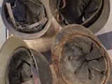 four hats sitting on top of a skateboard on the floor