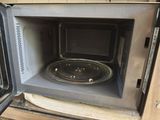 a microwave with a pan inside of it on the counter