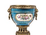 a large blue vase with a gold handle on a stand