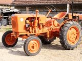 deux tracteurs orange garés l'un à côté de l'autre devant un bâtiment