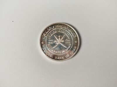 a silver coin on a white surface with a white background