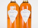 deux bouteilles de vin posées l'une à côté de l'autre sur une surface blanche