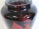 a vase that has a red and black design on it