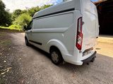 the back end of a white van parked in front of a garage