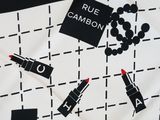 black and white print scarf with lipsticks on it with a black and white background