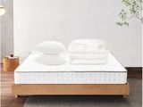a close up of a mattress on a wooden platform with pillows