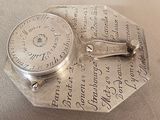 a silver plate with a clock on it on a table