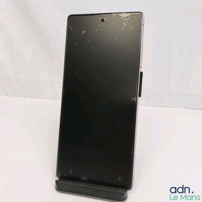 the back of a black cell phone sitting on top of a white table