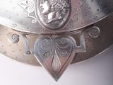 a silver plate with a face on it sitting on a table