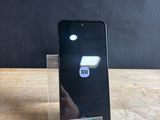the back of a black cell phone sitting on top of a wooden table