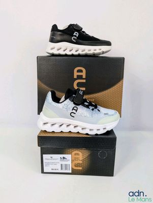 une paire de baskets noires et blanches posée sur une boîte