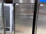 two stainless steel refrigerators in a store with glass doors