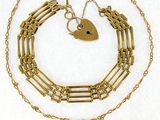 a close up of a gold chain with a heart on it
