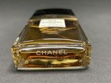 chanel perfume bottle on a table with a black background