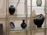 many glass shelves with vases on them in a room