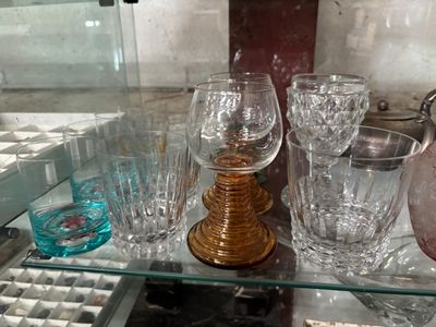 bottles and glasses on a glass shelf in a glass case