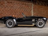 a black sports car parked in front of a brick wall