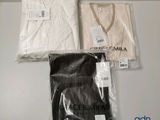 Il y a deux chemises blanches et une chemise noire sur une table