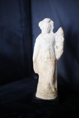 une statue blanche représentant un ange sur fond noir