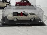 two toy cars in a display case on a table