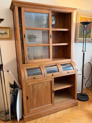 une armoire en bois avec une porte vitrée dans un salon