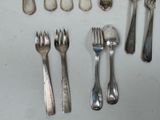 a lot of silver spoons and forks on the table