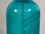 une bouteille en verre bleue munie d'une pompe métallique sur le dessus
