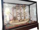 a glass case with a model of a ship in it