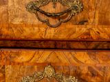 a wooden chest of drawers with brass hardware on it