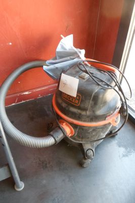 un aspirateur posé par terre près d'une fenêtre