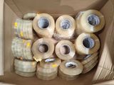 de nombreux rouleaux de ruban adhésif dans une boîte en carton posée par terre
