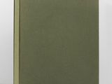 a green book sitting on top of a table next to a white wall