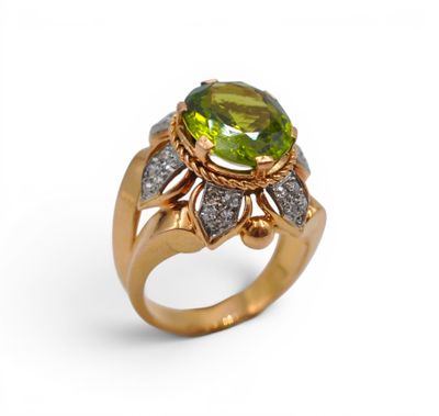 gros plan d'une bague avec une pierre verte entourée de diamants