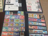 a lot of stamps on a table with a folder