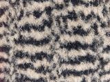 someone is knitting a hat with a zebra pattern on top of it