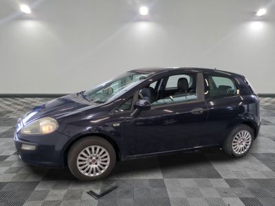 la photo d'une petite voiture bleue garée sur un sol en damier
