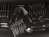 a lot of silver spoons and forks on the table