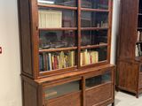 une bibliothèque en bois sur laquelle sont posés de nombreux livres, dans une pièce