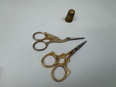 une paire de ciseaux et un écrou posés sur une table