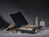 a black suitcase with a mirror, a brush, and other items in it