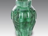 a green vase that is sitting on a table