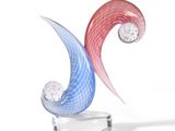a glass sculpture of a wave with two diamonds on it