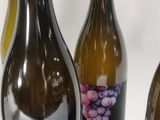 three bottles of wine with a bunch of grapes on them