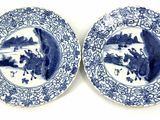 pair of blue and white plates with figures on them