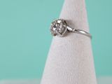 a close up of a diamond ring sitting on top of a white cone