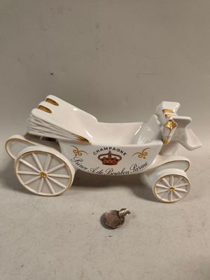porcelain figurine of a horse drawn carriage with a bird on the back