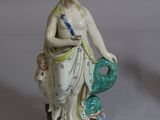 a figurine of a woman holding a fish on a table