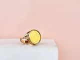 a close up of a gold coin ring on top of a marble block