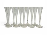 six verres à vin transparents alignés sur une surface blanche