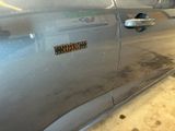 a silver car with a sticker on the side of it
